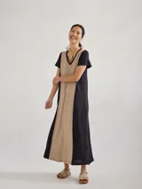 Vestido largo rojo de tejido de punto, con cuello en V y mangas cortas. Presenta costuras verticales a lo largo del vestido.