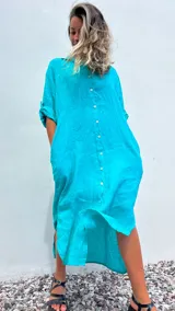 Vestido camisero largo color verde agua, confeccionado en lino 100%, con cuello camisero, abotonadura frontal completa, mangas 3/4 con trabilla y bolsillos laterales.