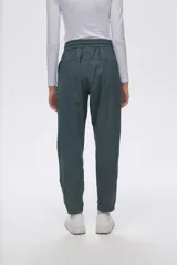 Pantalón de jogging color celeste con cintura elástica ajustable con cordón y puños elásticos. Presenta tres tiras verticales blancas en la parte inferior de la pierna.