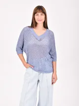 Buzo de tejido de punto calado color negro, con escote en V y mangas 3/4.