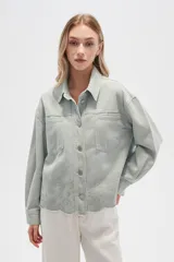 Campera de jean color crudo, de corte recto, con cuello clásico, cierre frontal con botones metálicos, dos bolsillos con solapa en el pecho y bajo con detalle de bordado calado.
