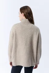 Polera beige melange de punto con cuello tortuga.