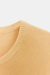 Top color amarillo de punto liso con cuello redondo y manga corta.