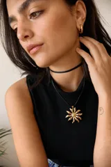 Collar con cadena fina y dije dorado en forma de flor.