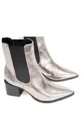 Bota corta plateada con textura de cuero metalizado, elásticos laterales negros y tacón cuadrado.