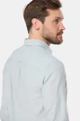 Camisa de manga larga, color celeste con finas rayas blancas, confeccionada en una mezcla de lino y algodón. Presenta un corte slim fit y no tiene bolsillo.