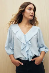 Blusa negra con mangas 3/4 y escote en V con volados.