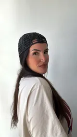 Gorro tipo turbante de malla calada color negro con detalles brillantes.