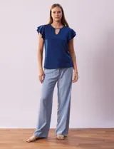 Blusa azul con cuello redondo, escote en V con aplique metálico y mangas cortas con volados en capas.