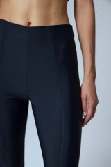 Pantalón oxford negro de tricot sin cintura, con costuras centrales en el delantero y tajos en la botamanga.