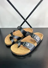 Sandalias de dedo negras con tiras finas de ecocuero y hebillas metálicas ajustables.