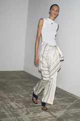 Top blanco de algodón con escote redondo, sin mangas y detalle de logo metálico en el pecho.