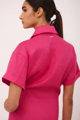 Vestido corto fucsia con cuello camisero, mangas cortas y lazo en la cintura.