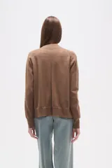 Cardigan de punto color blanco roto con motas oscuras, de manga larga y escote en V con cierre de botones frontales.