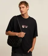 Remera negra de corte oversized con estampa en la espalda con la frase "Heart Eyes Only" y un oso cupido.
