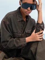 Campera de jean celeste con efecto lavado, corte cropped, cuello clásico, cierre frontal con botones metálicos, cuatro bolsillos frontales con solapa y puños abotonados.