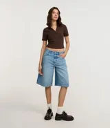 Blusa de punto acanalado (rib) color marrón oscuro, con cuello polo, escote en V y manga corta.