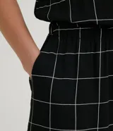 Mono corto negro con estampado de cuadrillé blanco, escote en V y tirantes anchos.