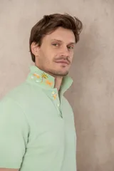 Remera tipo polo color beige, de manga corta y corte clásico. Tiene cuello con botones y está confeccionada en algodón.