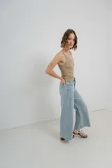 Pantalón de jean celeste claro, corte palazzo, tiro alto, bolsillos delanteros y traseros, y detalle metálico con el logo Peach en el bolsillo trasero.