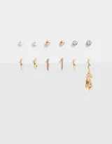 Set de seis pares de aros dorados: tres pares de aros tipo botón (con perla, con strass y liso) y tres pares de aros tipo argolla (lisos, con strass y con dije de zapatillas de ballet).