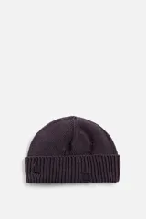 Gorro de lana tejido en punto morado oscuro, con vuelta y detalles rotos.