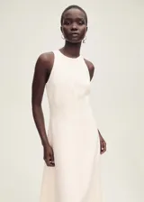 Vestido midi evasé color blanco hueso, sin mangas y cuello halter. Confeccionado en tejido mezcla de lino.