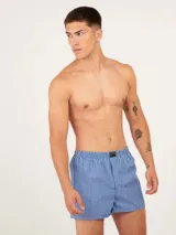 Bóxer de algodón blanco con estampado de flores pequeñas color celeste, con cintura elástica y logo de la marca en el centro.