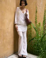 Pantalón blanco de gasa con cintura elastizada y cierre lateral. Incluye pollera superpuesta.