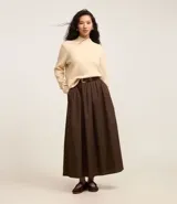 Sweater negro de punto con cuello redondo, puños y ruedo acanalados. Incluye cuello, puños y ruedo de camisa celeste a rayas.
