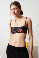 Top de bikini negro con estampado de jungla multicolor, corte recto y tirantes finos.