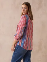Blusa de gasa estampada, marca Ruby Rd. Cuello a la base, escote en V y abertura central con botones. Delantera con plisados. Largo de manga regulable con presilla y botón.