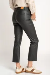 Pantalón negro de corte flare, tiro medio y efecto encerado.