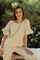 Pijama de algodón con estampado vichy, compuesto por una blusa de manga corta con volados y un pantalón capri con elástico en la cintura y volados en el ruedo.