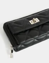 Billetera negra de cuerina con diseño acolchado, formato fichero, bolsillo frontal con broche y botón, cierre superior circundante y monedero interno con cierre.