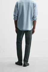 Pantalón de jean azul oscuro, corte slim fit, tiro medio, cinco bolsillos, tejido elástico y efecto lavado.