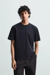 Camiseta blanca de algodón de peso medio, corte recto, cuello redondo y mangas cortas.