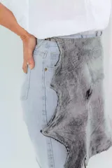 Bermuda de denim celeste con sobrepollera de cuero color suela desmontable.