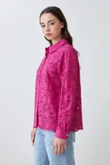 Camisa fucsia de broderie con cuello clásico, cierre frontal con botones y mangas largas.