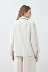 Camisa beige melange con frunces en el frente, de manga larga y cuello camisero.