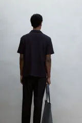 Remera negra de punto texturizado de mezcla de algodón con cuello y miniabertura en V. Corte estándar.