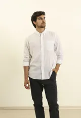 Camisa azul marino de lino y algodón, con cuello abotonado, manga larga con puños enrollados, bolsillo de parche en el pecho y cierre frontal con botones.