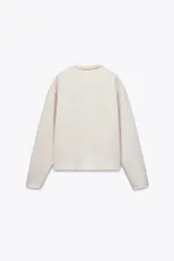 Sweater color crudo de cuello redondo y manga larga.