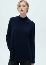 Sweater azul marino de punto fino con cuello perkins, corte oversize y mangas largas.