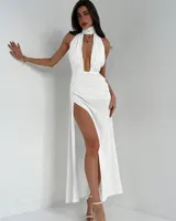 Vestido blanco de corte midi, con escote halter y abertura en la pierna.