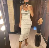 Vestido largo de tejido blanco con detalles en negro, de tirantes delgados y diseño ajustado.