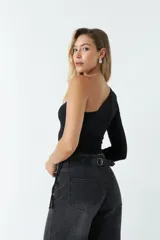 Top asimétrico blanco de una sola manga con jaretas ajustables en ambos lados del torso para regular el largo.