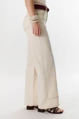 Pantalón negro de corte recto, pierna ancha y tiro alto, con detalles de pespuntes blancos a contratono.