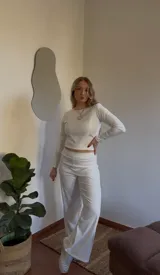 Conjunto de pantalón y top de jersey color crudo. El top es de manga larga y cuello redondo. El pantalón es de corte recto y tiro alto.