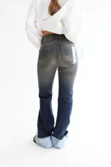Pantalón jean oxford de tiro alto, color azul oscuro con desgaste en los muslos y rodillas. Presenta alforzas en el delantero y dobladillo en la botamanga.